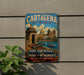 A vintage-style metal sign for Cartagena, Colombia, featuring a colorful illustration of the city's landmarks and a boat on the water.