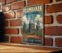 A vintage-style metal sign with the text "Prambanan Temple Compounds" and "Indonesia" is displayed on a brick wall.
