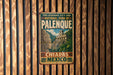 A vintage-style metal sign with text and an illustration of a temple, hanging on a wooden wall.