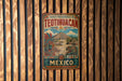A vintage metal sign with the text "CUADAD PREHISPANICA DE TEOTIHUACAN" and "MEXICO" is displayed on a wooden wall.