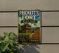 A vintage metal sign for Prickett's Fort State Park in West Virginia, featuring a wooden cabin and a flag, mounted on a wall.
