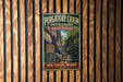 A vintage metal sign for the Purgatory Chasm State Reserve in Massachusetts, featuring a scenic image of a rocky trail leading up to a waterfall.