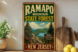 A vintage-style metal sign for Ramapo Mountain State Forest in New Jersey, featuring a scenic landscape with pine trees, mountains, and a river.