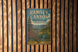 A vintage metal sign for Ramsey Canyon Preserve in Arizona, featuring a scenic landscape with mountains, flowers, and a river.