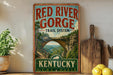 A vintage-style sign for the Red River Gorge Trail System in Kentucky, featuring a scenic illustration of the arch and the surrounding landscape.