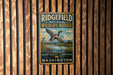 A vintage metal sign for Ridgefield National Wildlife Refuge hanging on a wooden wall.