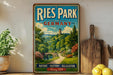 a vintage-style sign for Ries Park, Germany, with a scenic landscape depicting a bridge, trees, and a river. The sign is displayed on a wooden shelf, surrounded by various kitchen utensils and a potted plant.