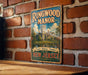 A vintage-style metal sign for Ringwood Manor, a historic mansion in New Jersey, is displayed on a brick wall.