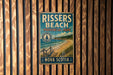 A vintage-style metal sign for Rissers Beach, a coastal park in Nova Scotia, Canada.
