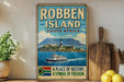 a vintage-style sign for Robben Island, South Africa, with a lighthouse and a boat on the water.