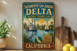 A vintage-style metal sign for the Sacramento Delta National Heritage Area in California, featuring illustrations of a river, a steamboat, and a bird.