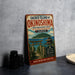 A vintage-style metal sign advertising the Sacred Island of Okinawa, Japan, with a scenic illustration of a temple and a body of water.