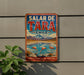 A vintage metal sign with the text "SALAR DE TARA CHILE" and an illustration of a scenic landscape with mountains, water, and flamingos.
