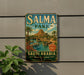 A vintage-style metal sign for Salma Park in Saudi Arabia, featuring a scenic landscape with palm trees, waterfalls, and a castle-like structure.