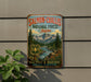 A vintage-style sign for Salmon-Challa's National Forest in Idaho, featuring a scenic mountain landscape with a river and rugged peaks.