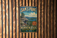 A vintage-style metal sign for Sam's Point Area, Minnewaska State Park Preserve, New York, featuring a scenic landscape with a cliff and a lake.