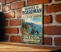 A vintage-style metal sign for the State Scenic Corridor in Oregon, featuring a scenic coastal landscape with mountains, water, and trees.