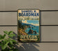 A vintage-style metal sign for the State Scenic Corridor in Oregon, featuring a scenic coastal landscape with mountains, trees, and the ocean.