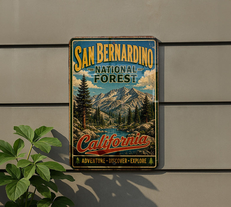 A vintage-style metal sign for the San Bernardino National Forest in California, featuring a scenic mountain landscape and the text "San Bernardino National Forest" and "California Adventure - Discover - Explore".