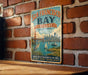 A vintage-style metal sign with the text "SAN FRANCISCO BAY ESTUARY UNITED STATES" and a picture of the Golden Gate Bridge, along with the text "WHERE FRESH WATER MEETS THE SEA" and "WILDLIFE • HISTORY • NATURAL BEAUTY".