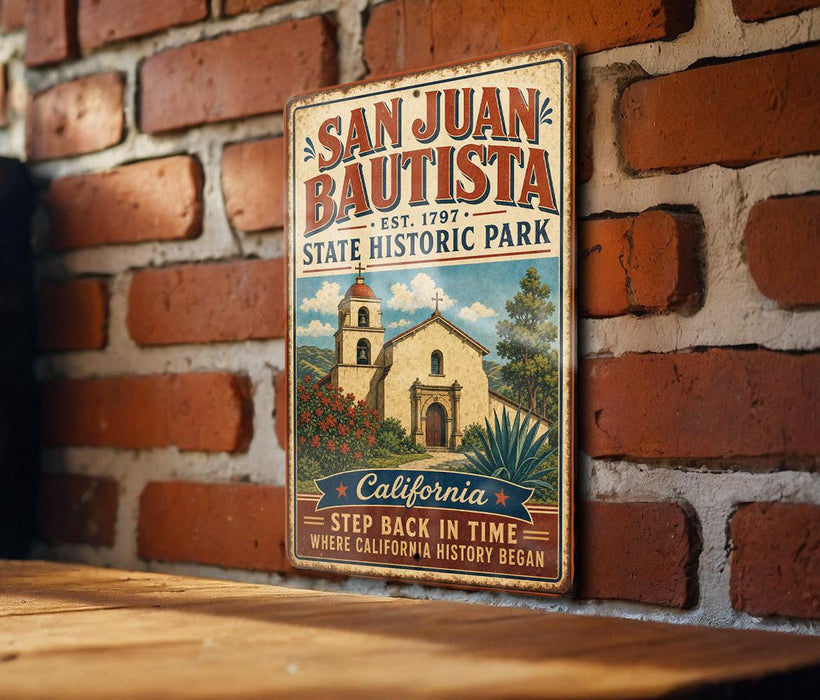 A vintage-style metal sign for San Juan Bautista State Historic Park, featuring an illustration of a historic building and surrounded by lush greenery.