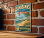 A vintage-style metal sign for Sandbanks Provincial Park, Ontario, Canada, featuring a beach scene with a tree and ocean.