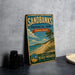 A vintage-style sign for Sandbanks Provincial Park, Ontario, Canada, featuring a beach scene and the text "Sandbanks Ontario Canada Beach Paradise Swim + Hike + Explore"