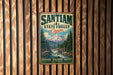 A vintage metal sign with the text "SANTIAM A STATE FOREST OREGON EXPLORE • DISCOVER • PROTECT" is displayed on a wooden wall.