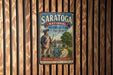 A vintage-style metal sign for Saratoga National Historical Park in New York, featuring a depiction of a man in a historical uniform and the text "Preserving America's Heritage" and "Discovery, Learning, Exploring".