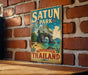 A vintage metal sign with the text "SATUN PARK" and "THE HIDDEN PARADISE THAILAND" hangs on a brick wall.