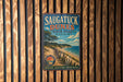 A vintage metal sign for Saugatuck Dunes State Park in Michigan, featuring a scenic beach and ocean landscape.