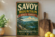 a vintage-style sign for Savoy Mountain State Forest in Massachusetts, with a scenic mountain landscape and a lake in the background.