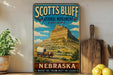 A vintage-style sign for the National Monument in Nebraska, featuring a wagon traveling through the landscape.
