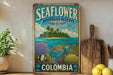 a vintage-style metal sign with a tropical island scene, a sea turtle, and various marine life, including a coral reef and a fish. The sign is displayed on a shelf next to a wooden cutting board and a potted plant.