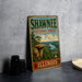 A vintage-style sign for Shawnee National Forest in Illinois, featuring a scenic landscape with a river and mountains.