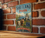 A vintage-style metal sign for Shetland Park, featuring a castle and a pony, is displayed on a brick wall.