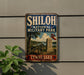 A vintage metal sign for Shiloh National Military Park in Tennessee, featuring a cannon and a flag, mounted on a wall.