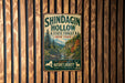 A vintage metal sign for Shindagin Hollow State Forest in New York, featuring a scenic illustration of the forest and mountains.