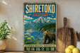 A vintage-style poster of Shiretoko, Japan, featuring a scenic landscape with a bear, mountains, and a boat on the water.