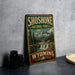 A vintage-style sign for Shoshone National Forest in Wyoming, featuring a scenic mountain landscape with a waterfall.