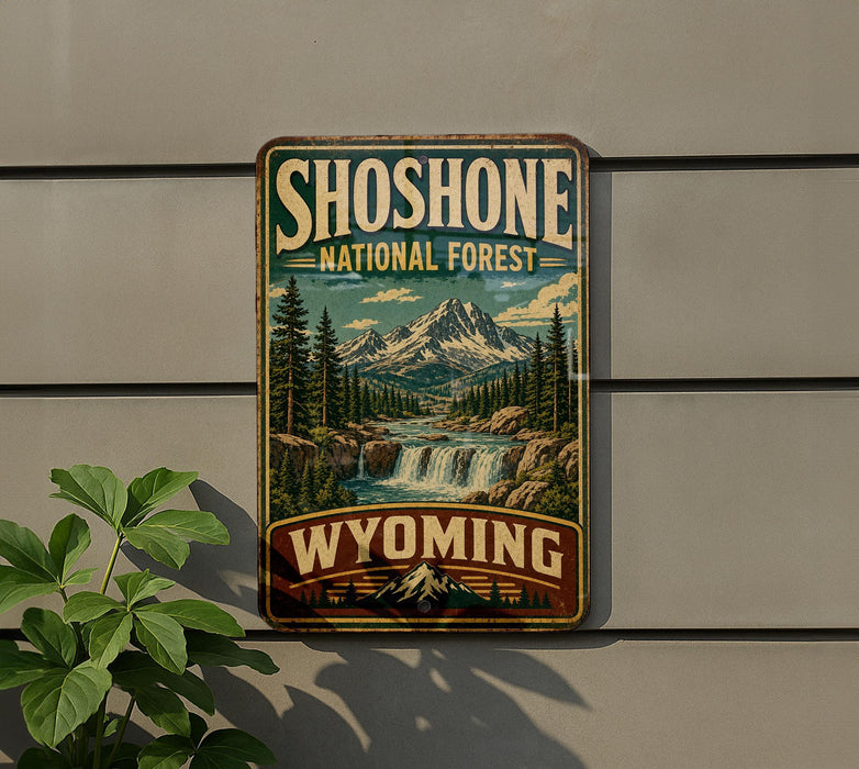 A vintage-style metal sign for Shoshone National Forest in Wyoming, featuring a scenic mountain landscape with a waterfall.