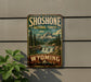 A vintage-style metal sign for Shoshone National Forest in Wyoming, featuring a scenic mountain landscape with a waterfall.