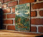 A vintage-style metal sign with a leopard and tropical plants, mounted on a brick wall.