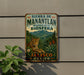 A vintage-style metal sign with a leopard and lush greenery, advertising the Sierra de Manantlan Reserve of the Biosfera in Jalisco, Mexico.