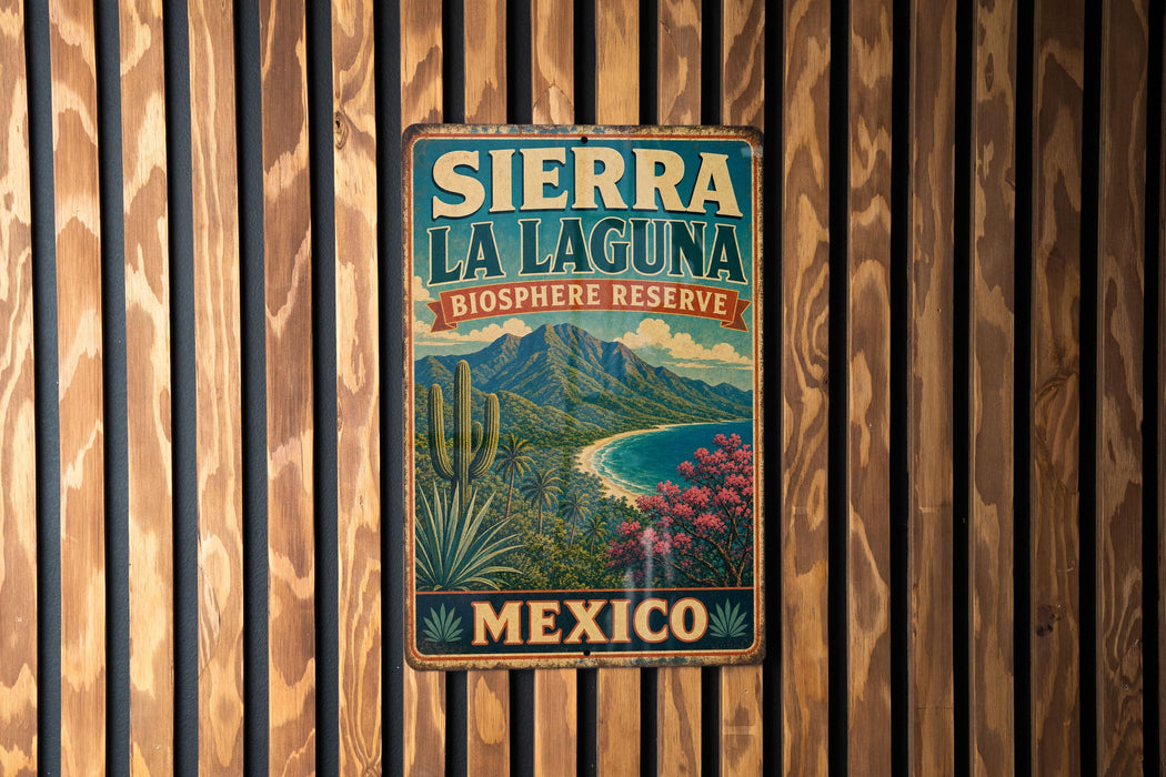 A vintage-style metal sign for Sierra La Laguna Biosphere Reserve in Mexico, featuring a desert landscape with mountains, cacti, and a beach.
