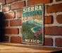 A vintage-style metal sign with the text "SIERRA LA LAGAÑA BIOSPHERE RESERVE MEXICO" is displayed on a brick wall.