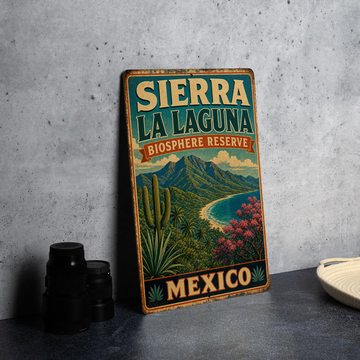 A vintage-style sign for Sierra La Laguna Biosphere Reserve in Mexico, featuring a scenic landscape with mountains, palm trees, and a beach.