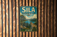A vintage-style metal sign for Sila Biosphere Reserve in Italy, featuring a wolf and a forest landscape.