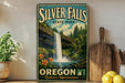 A vintage-style metal sign for Silver Falls State Park in Oregon, featuring a waterfall surrounded by lush greenery and flowers.