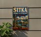 A vintage-style metal sign for Sitka National Historical Park in Alaska, featuring a mountain landscape and a canoe on the water.